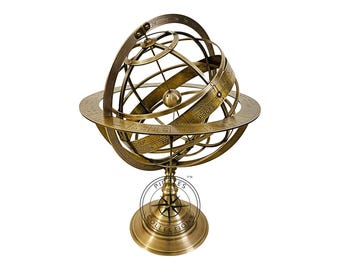 Puede incluir: Un globo celeste de latón con un diseño detallado, que presenta los signos del zodíaco y las constelaciones. El globo está montado en un soporte con un diseño de brújula y el texto "Pirates Collections" en la base.