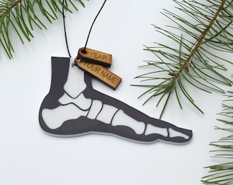 May include: A black and white foot bone ornament with a wooden tag that says "YEAR" and another wooden tag that says "YOUR NAME".
