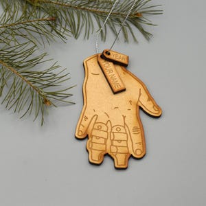 May include: Wooden Christmas ornament shaped like a hand with a tag that says "Your Name" and "Year".