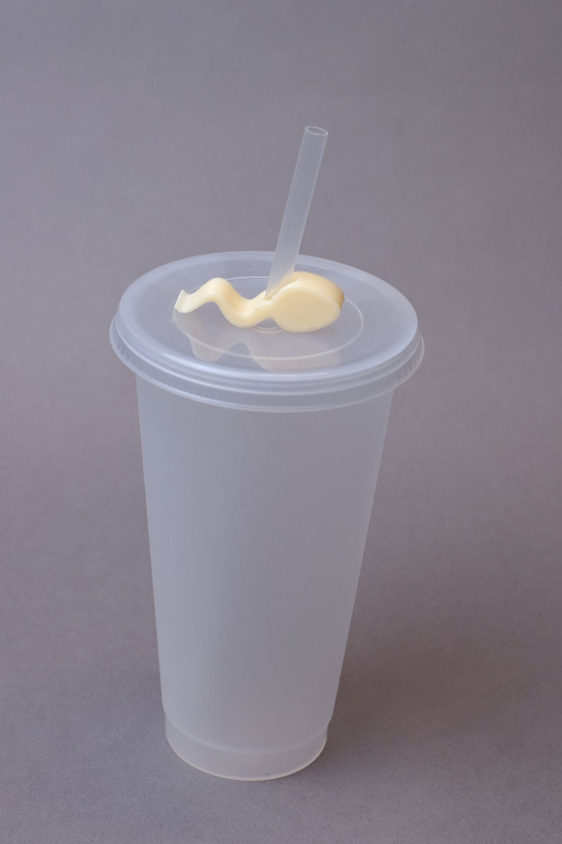 Puede incluir: Un vaso de pl&aacute;stico transparente con tapa y una pajita. La pajita est&aacute; doblada y pegada a la tapa.