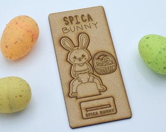 May include: A wooden cutout of a bunny holding a basket of Easter eggs. The cutout is labeled "Spica Bunny".