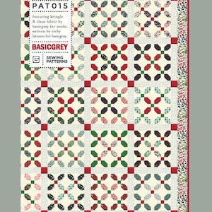 May include: A patchwork quilt with a repeating pattern of red, green, and blue floral shapes on a cream background. The quilt has a red border with floral accents and the text "HOHO HOLLY PAT015" is visible.