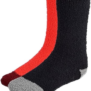 May include: A pair of fluffy socks with a black and red colour block design. The socks have a grey toe and heel.