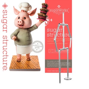 May include: A silver metal stand for building sugar structures. The stand is made of pipes and connectors and is adjustable to different heights. The stand is shown with a pig wearing a chef's hat holding a cake. The text on the stand reads "sugar structure".