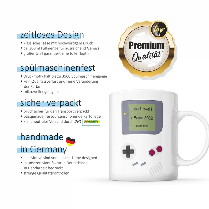 Puede incluir: Taza de cer&aacute;mica blanca con un gr&aacute;fico de una consola de videojuegos retro. La taza tiene un asa negra y el texto "New Level! > Papa 2022" en la pantalla de la consola. La taza est&aacute; etiquetada como "Premium Qualit&auml;t" y "hecho a mano en Alemania".