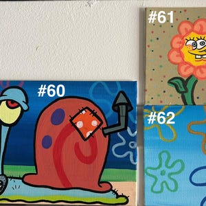 Op de afbeelding: Vier kleine vierkante schilderijen met personages en elementen uit de animatieserie SpongeBob SquarePants. De schilderijen bevatten Gary de Slak, SpongeBob als bloem en SpongeBobs iconische zeester- en bloemontwerpen. Elk schilderij heeft een nummer.