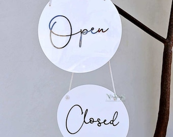 May include: Two white round signs with black text. The top sign says "Open" and the bottom sign says "Closed".