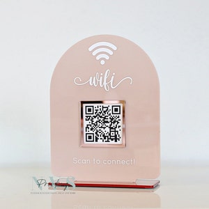 May include: A blush pink acrylic WiFi sign with a QR code for easy connection. The sign features the word "wifi" in a cursive font, a WiFi symbol, and the text "Scan to connect!"
