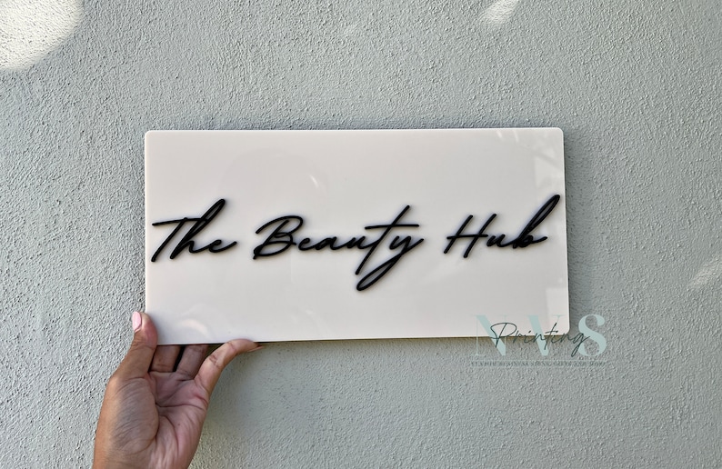 Custom Rectangle acrylic business sign in beige  colour, THE BEAUTY HUB in cursive font displayed on the middle in 3D gloss black acrylic