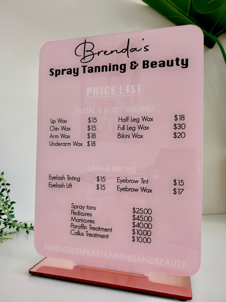 May include: A pink and black sign with the text "Brenda's Spray Tanning & Beauty" and a price list for various services, including waxing, lash and brow services, spray tans, pedicures, manicures, paraffin treatment, and callus treatment.