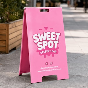 May include: A pink A-frame sidewalk sign featuring the white text SWEET SPOT DESSERT BAR with a heart icon. Below the text are Facebook and Instagram icons, the handle @sweetspotdessertbar, and the website www.sweetspotdessertbar.com.au.