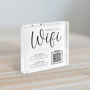Op de afbeelding: Een wit acryl bord met zwarte tekst die "Connect to our Wifi" luidt. Het bord bevat ook een zwart-witte QR-code met de tekst "Scan Me" en twee lege witte vakjes met de tekst "Network Wifi Name" en "Password Wifi Password".