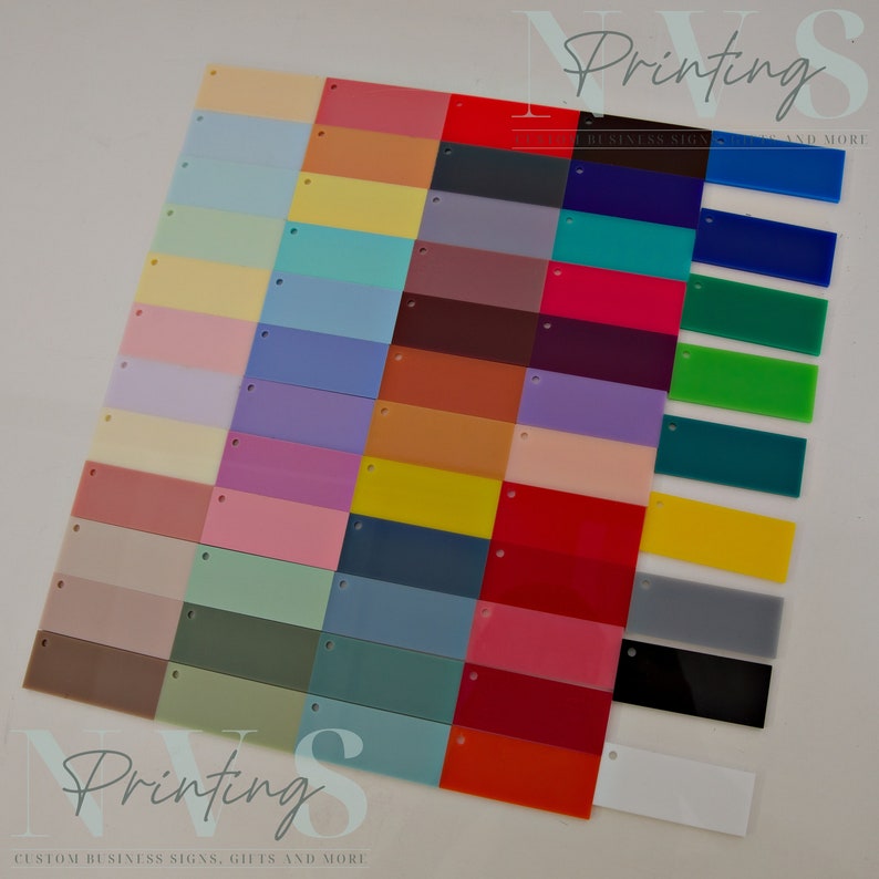 May include: A selection of rectangular acrylic colour swatches in various shades, including pink, blue, green, yellow, and purple. Each swatch has a small hole at the top. The image includes the text "NVS Printing" and "CUSTOM BUSINESS SIGNS, GIFTS AND MORE."