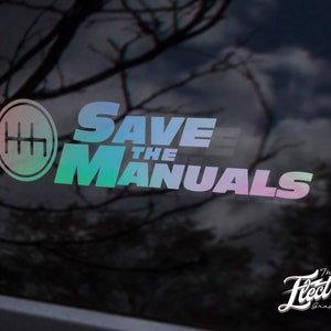 Könnte beinhalten: Ein regenbogenfarbener, schimmernder Vinyl-Aufkleber mit dem Text "Save the Manuals" und einem Schaltmuster. Der Aufkleber befindet sich auf einer schwarzen Autoscheibe.
