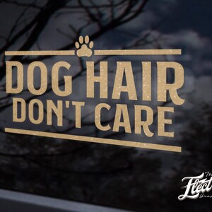 Op de afbeelding: Gouden glitter sticker met de tekst "Dog Hair Don't Care" en een poot afdruk. De sticker is op een zwarte achtergrond.
