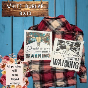 May include: White burlap patches with a distressed bull skull design and the text "Should've come with a warning." The patches are 8x10 inches and have frayed edges. A red and beige plaid shirt is in the background.
