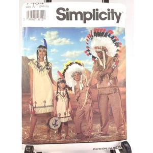 May include: Simplicity sewing pattern 7404 size A (SM-LG) featuring illustrations of four individuals wearing tan fringe costumes with decorative accents, including feathered headdresses and headbands, set against a desert landscape background.