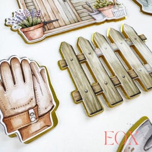 Puede incluir: Ilustraciones de acuarela con tem&aacute;tica de jardiner&iacute;a. La imagen presenta una valla de madera, guantes de jardiner&iacute;a, un cobertizo y plantas en macetas. Las ilustraciones tienen bordes dorados y est&aacute;n sobre un fondo blanco.