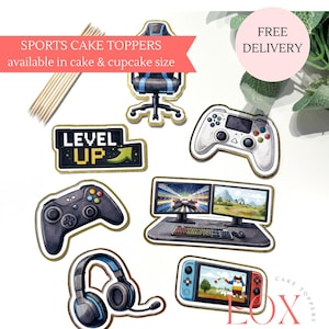 May include: A selection of cake toppers with a gaming theme, featuring a gaming chair, controllers, a computer setup, headphones, and a handheld console. The toppers have gold edging and the text "LEVEL UP". Available in cake and cupcake sizes.
