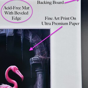 Op de afbeelding: Een fine art print op ultra premium papier, met een roze flamingo die voor een stenen boog staat. De print is gemat met een zuurvrije mat met een afgeschuinde rand en gemonteerd op een achterplaat.