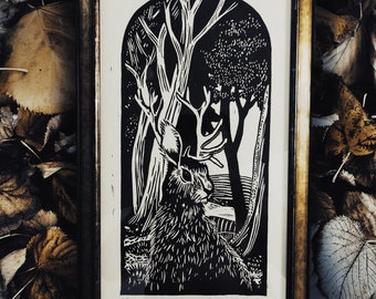 May include: Black and white woodblock print of a jackalope in a forest setting. The print is framed in a gold frame and has the text "The Jackalope" written below it.