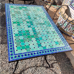 May include: A rectangular table with a blue and green mosaic tile top. The table has a black metal frame and legs.