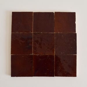 Könnte beinhalten: Neun braune glasierte Keramikfliesen in einem 3x3 Raster angeordnet.