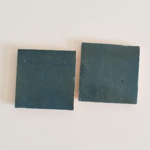 Op de afbeelding: Twee vierkante teal keramische tegels.