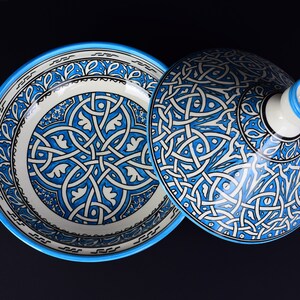 May include: A blue and white ceramic bowl with a lid. The bowl and lid are decorated with intricate geometric patterns.