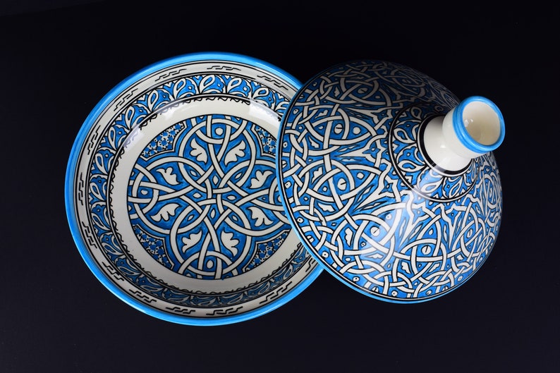 May include: A blue and white ceramic bowl with a lid. The bowl and lid are decorated with intricate geometric patterns.