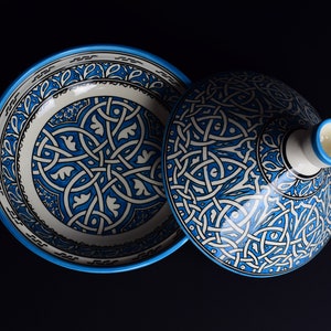 May include: A blue and white ceramic bowl with a lid. The bowl and lid are decorated with intricate geometric patterns.