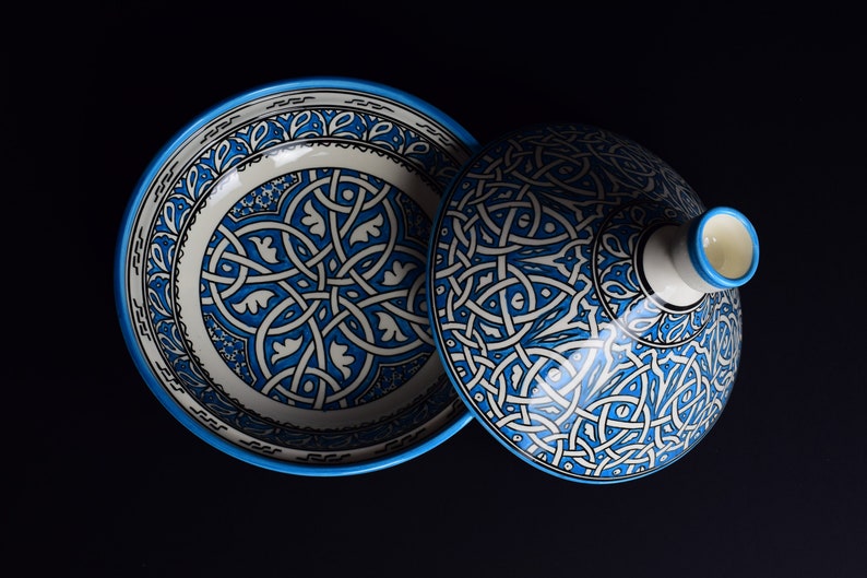 May include: A blue and white ceramic bowl with a lid. The bowl and lid are decorated with intricate geometric patterns.