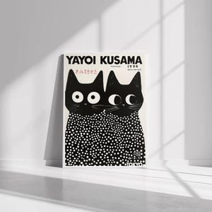 Può includere: Un poster con due illustrazioni di gatti neri con grandi occhi bianchi. I gatti sono su uno sfondo bianco e hanno un motivo a pois sui loro corpi. Il poster recita "YAYOI KUSAMA 1996".
