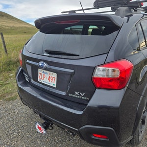 K&ouml;nnte beinhalten: Ein schwarzer Subaru XV Crosstrek mit einem Heckspoiler und einem Nummernschild mit der Aufschrift "ZLP-497". Das Auto hat eine Anh&auml;ngerkupplung mit einem Logo der Kansas City Chiefs.