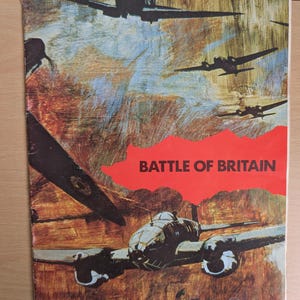May include: A rectangular book cover featuring a painted scene of multiple military aircraft in flight. The text BATTLE OF BRITAIN is printed in black capital letters over a bright red, jagged-edged shape centred on the cover against a brown background.