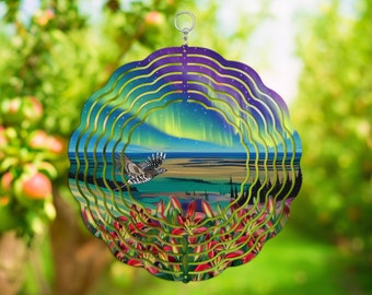 May include: A metal wind spinner with a multi-colored design featuring a bird flying over a landscape with a green field, trees, and a blue sky with stars and a green aurora borealis. The wind spinner has a silver hanger.
