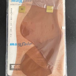 Może przedstawiać: Para bezszwowych, odpornych na oczka pończoch Mayfair w kolorze Rosewood, rozmiar 9 1/2, zapakowanych w przezroczysty plastikowy rękaw. Opakowanie zawiera nazwę marki Mayfair, tekst seamfree run-resist oraz logo firmy Celon Courtaulds.