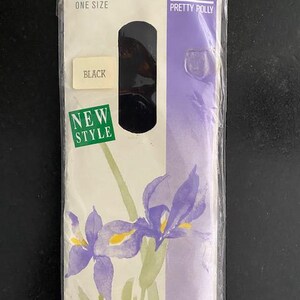 Op de afbeelding: Een verpakking zwarte kousen van Pretty Polly in één maat. De verpakking heeft een witte achtergrond met een paarse verticale streep, een groen New Style-label en een aquarelillustratie van paarse irissen met groene stengels.