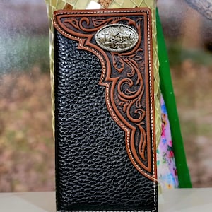 May include: Black leather wallet with brown embossed floral design and a silver-colored metal emblem. The wallet has a bi-fold design with white stitching and a textured surface.