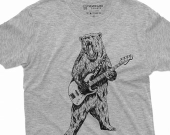 Puede incluir: Una camiseta gris con una ilustración en blanco y negro de un oso tocando un bajo.