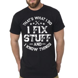 Puede incluir: Camiseta negra con un gráfico blanco que dice "That's what I do I fix stuff and I know things" con una llave inglesa y tres estrellas.
