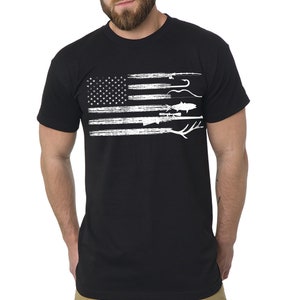 Puede incluir: Camiseta negra con un diseño de bandera estadounidense blanca desgastada que presenta imágenes de pesca y caza.