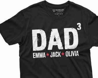 Può includere: Maglietta nera con testo bianco che recita "DAD" con un apice "3" e i nomi "EMMA", "JACK" e "OLIVIA" con stelle rosse tra ogni nome.