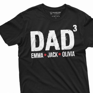 May include: Black t-shirt with white text that reads "DAD" with a superscript "3" and the names "EMMA", "JACK", and "OLIVIA" with red stars between each name.