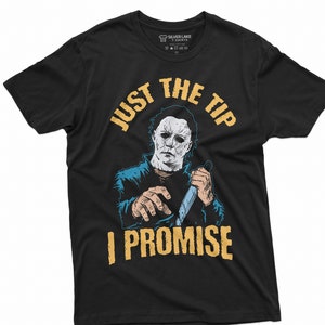May include: Black t-shirt with a graphic of a masked figure holding a knife, and the text "JUST THE TIP I PROMISE" in yellow. The shirt is from Silver Lake T-Shirts.