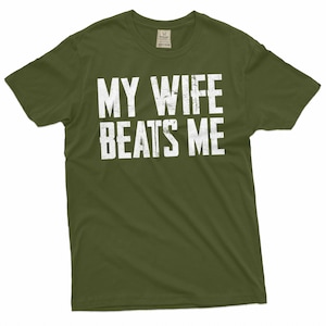 May include: A green t-shirt with the text "MY WIFE BEATS ME" printed in white.