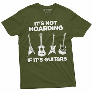 May include: A green t-shirt with a white graphic that says "It's not hoarding if it's guitars". The graphic features five guitars in a row, including an acoustic guitar, an electric guitar, and a bass guitar.