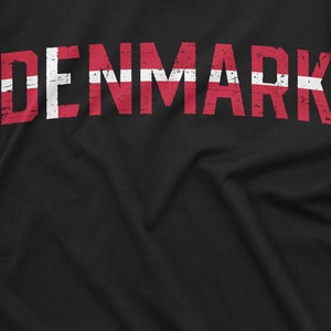 May include: Black t-shirt with the word "DENMARK" printed in red and white, resembling the Danish flag.