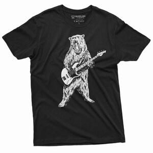 K&ouml;nnte beinhalten: Schwarzes T-Shirt mit einer wei&szlig;en Illustration eines B&auml;ren, der Bass spielt.