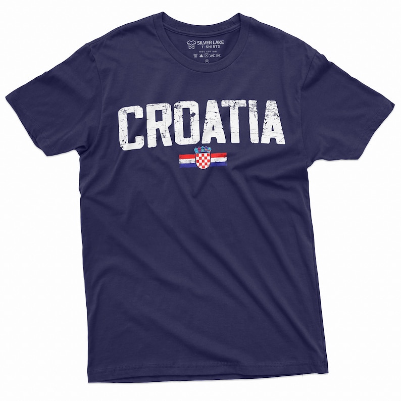 以下が含まれることがあります： 紺色のTシャツに、かすれたような白い文字で「CROATIA」とプリントされています。文字の下にはクロアチアの旗がプリントされています。